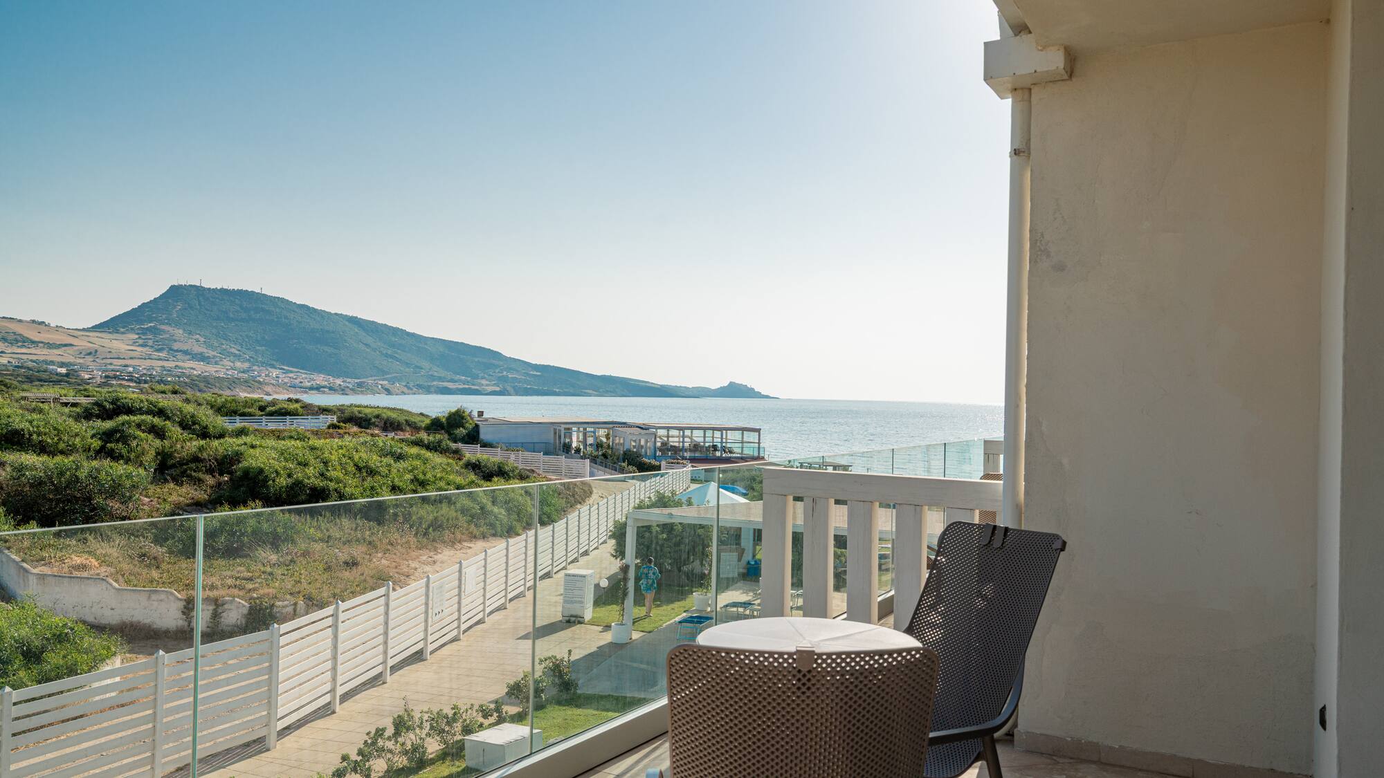 a chair and table on a balcony overlooking a body of water