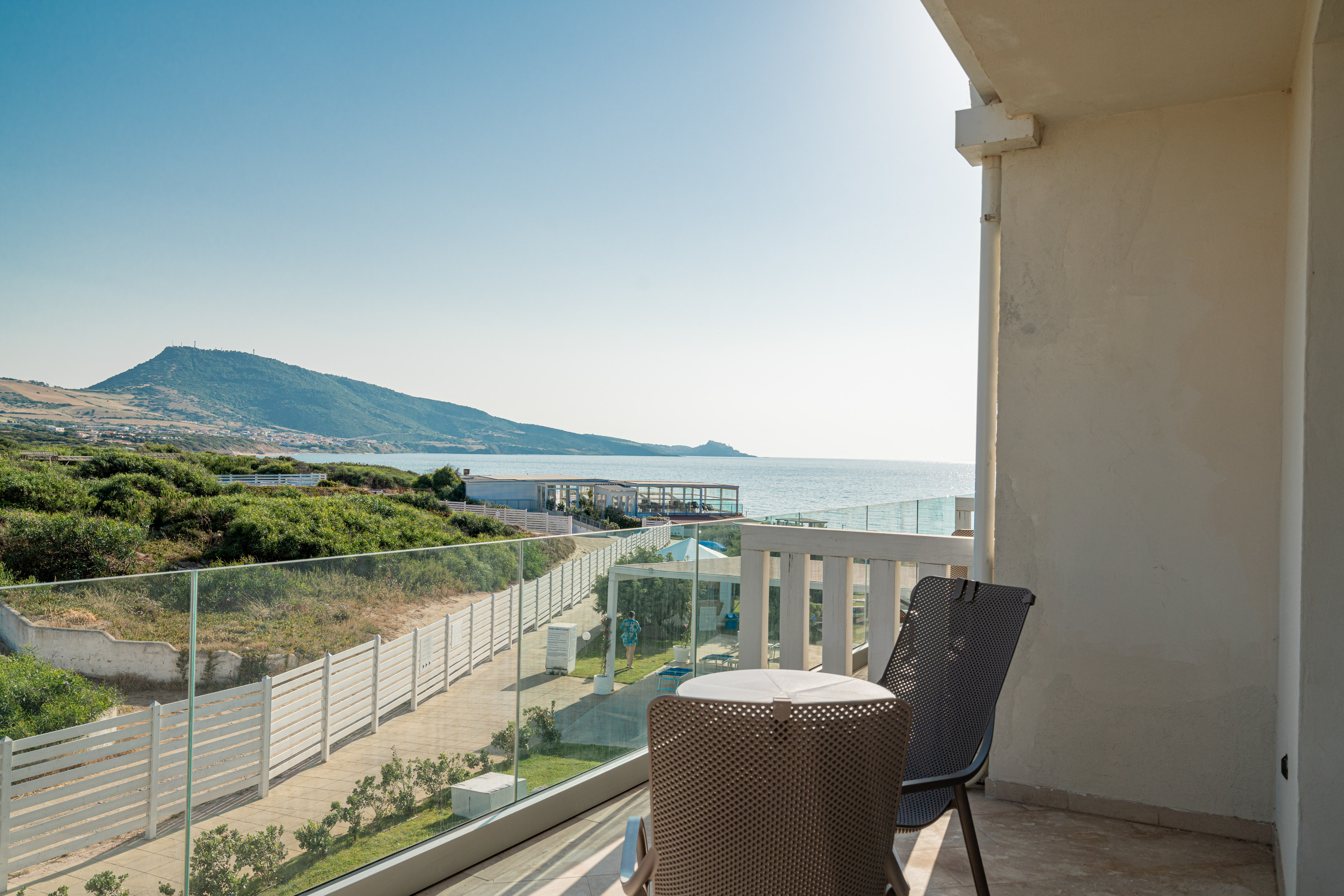 a chair and table on a balcony overlooking a body of water