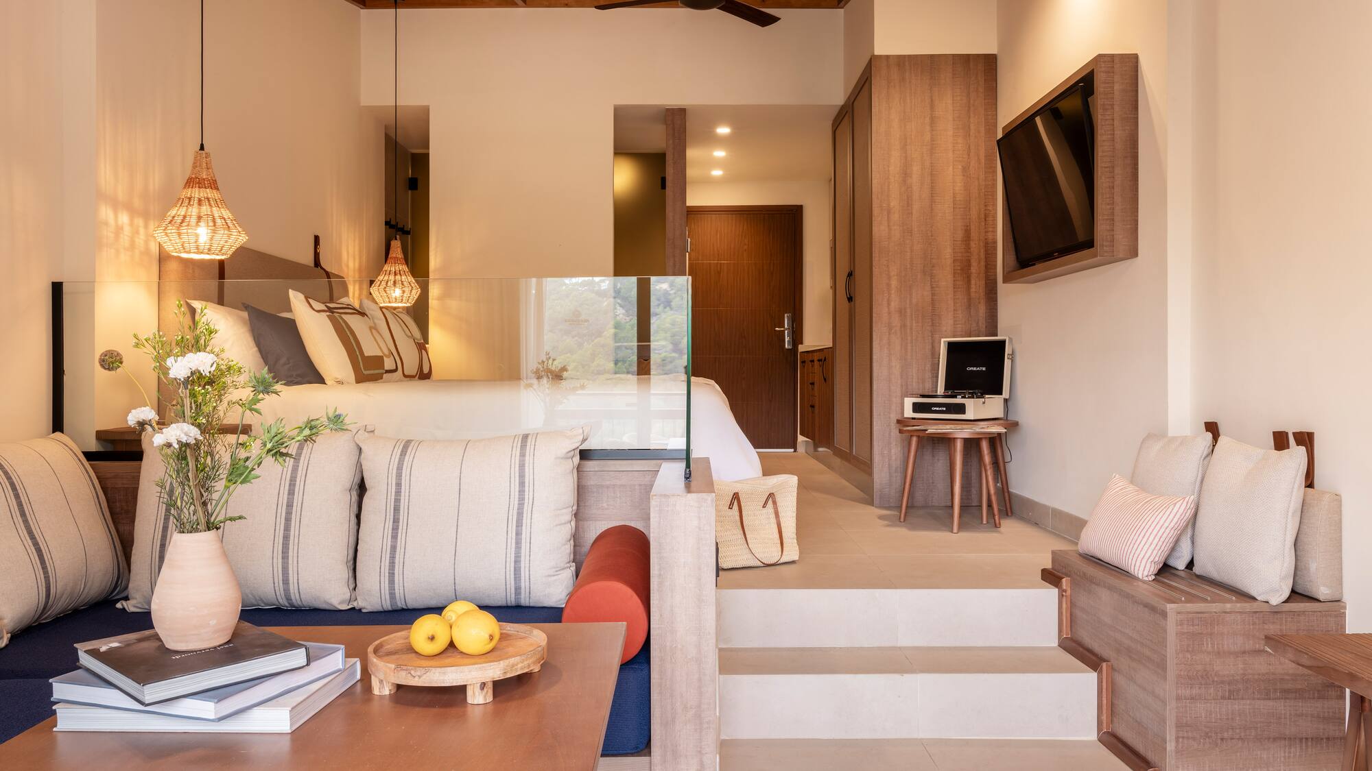 a room with stairs and couch and a tv