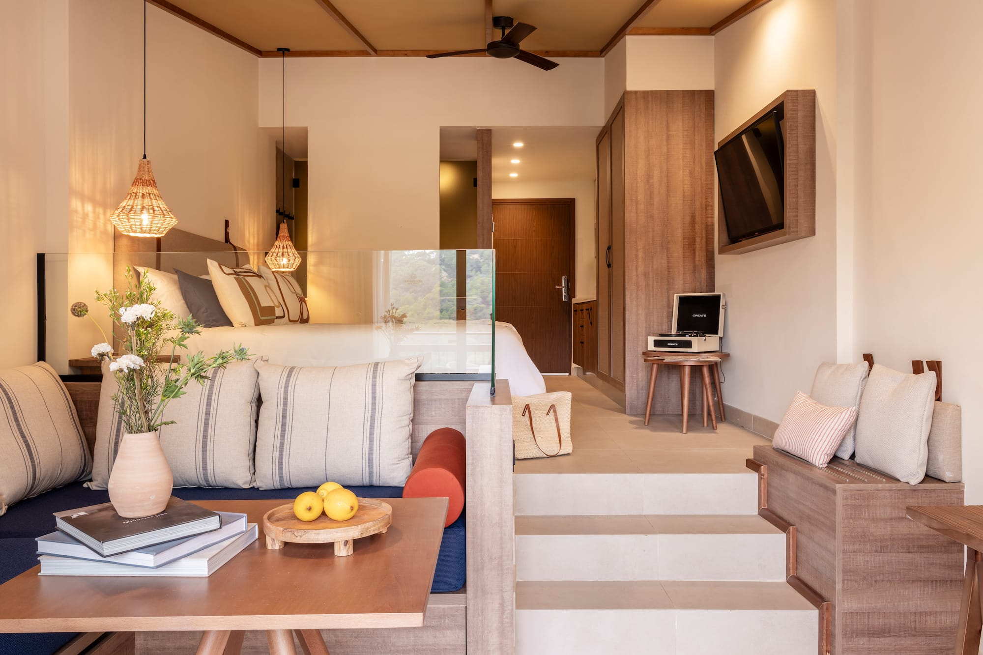 a room with stairs and couch and a tv