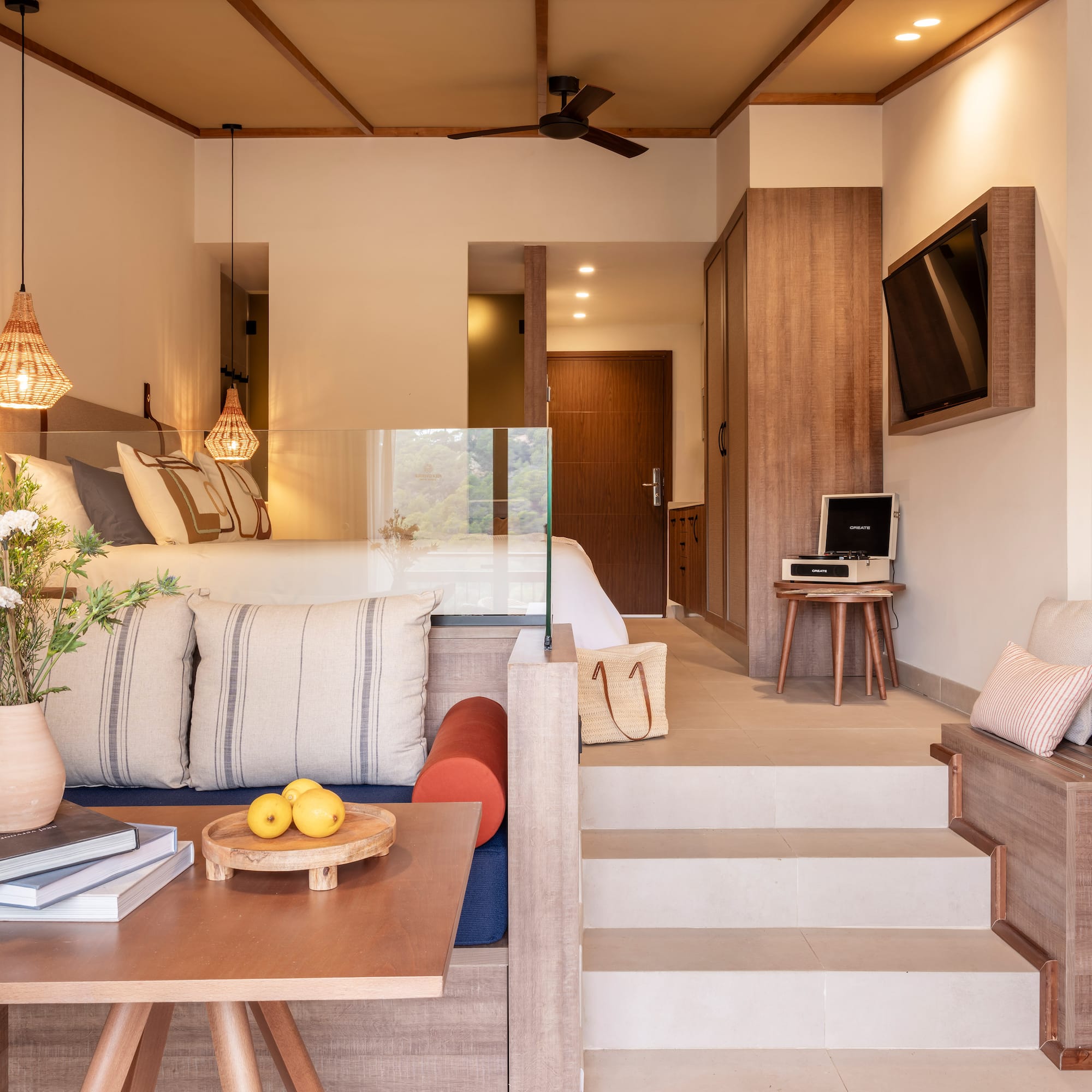 a room with stairs and couch and a tv