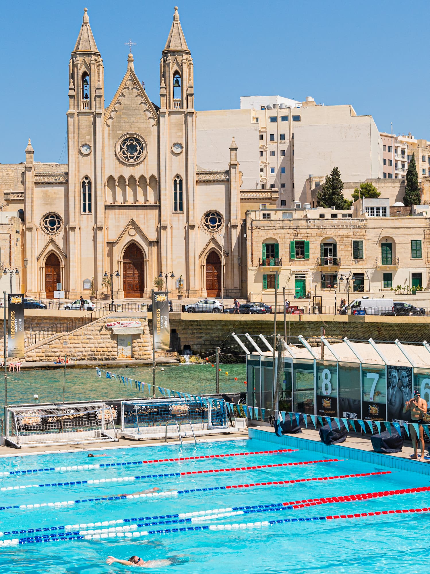 a swimming pool with a large building in the background