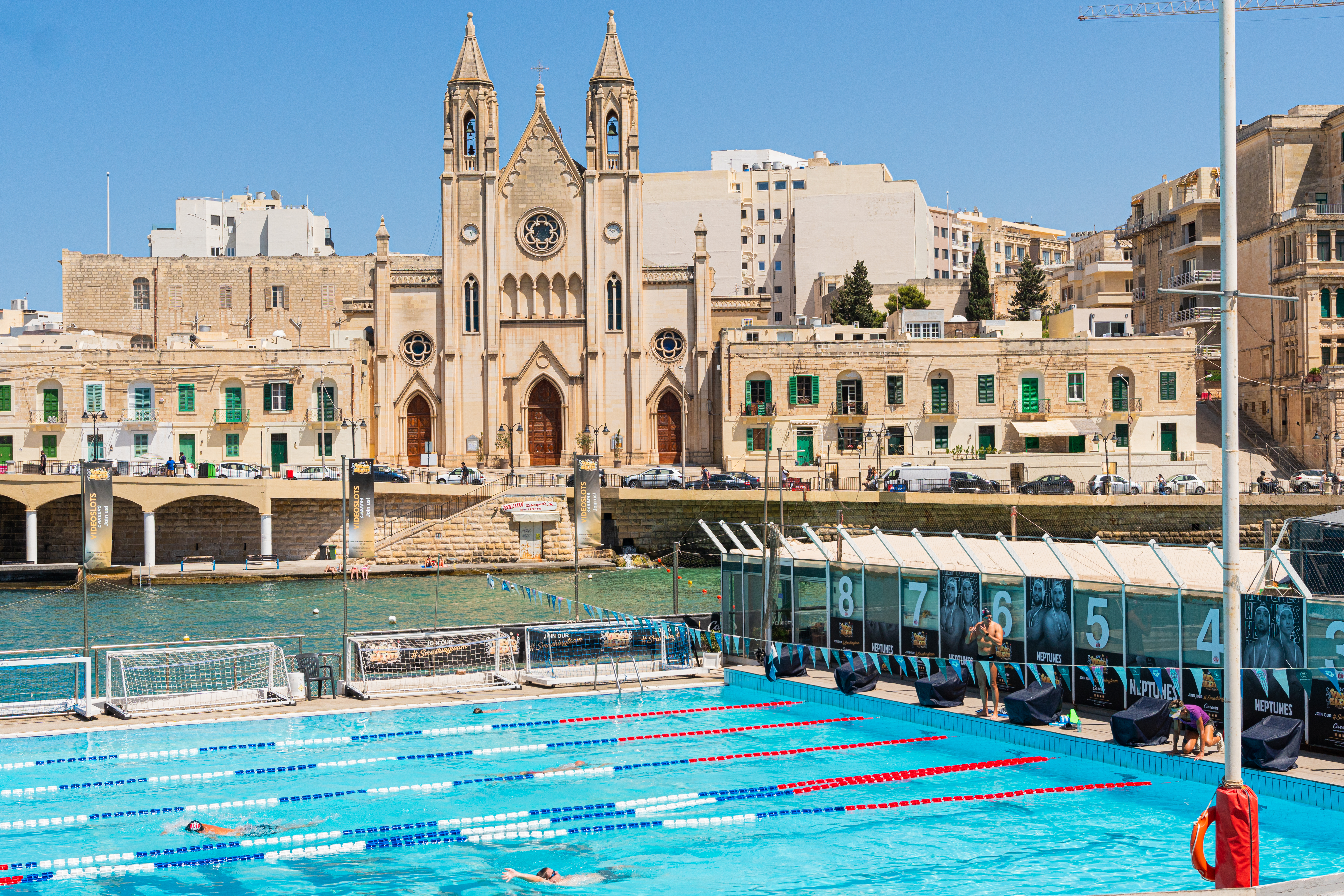 a swimming pool with a large building in the background