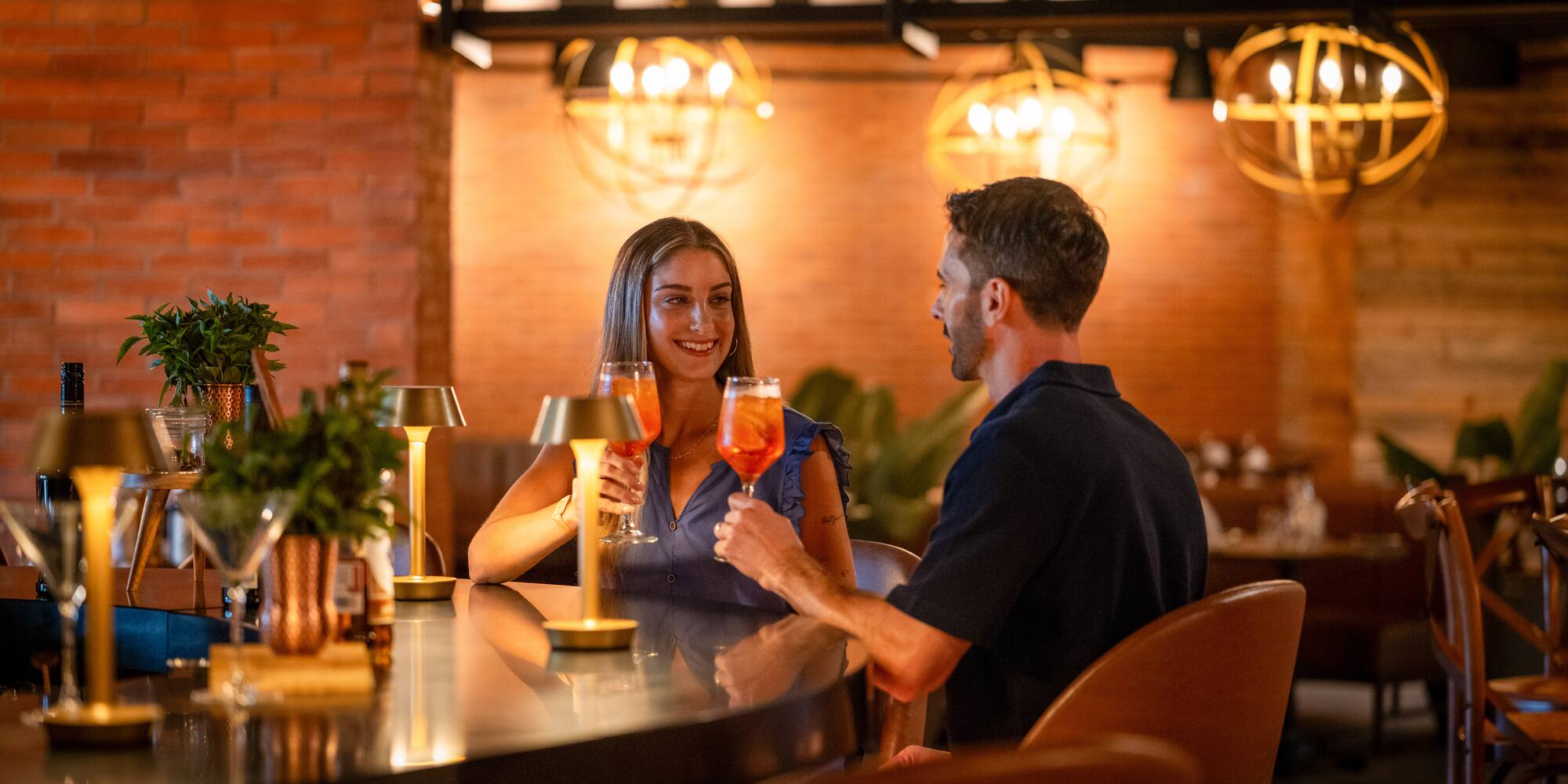 a man and woman sitting at a bar