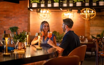 a man and woman sitting at a bar