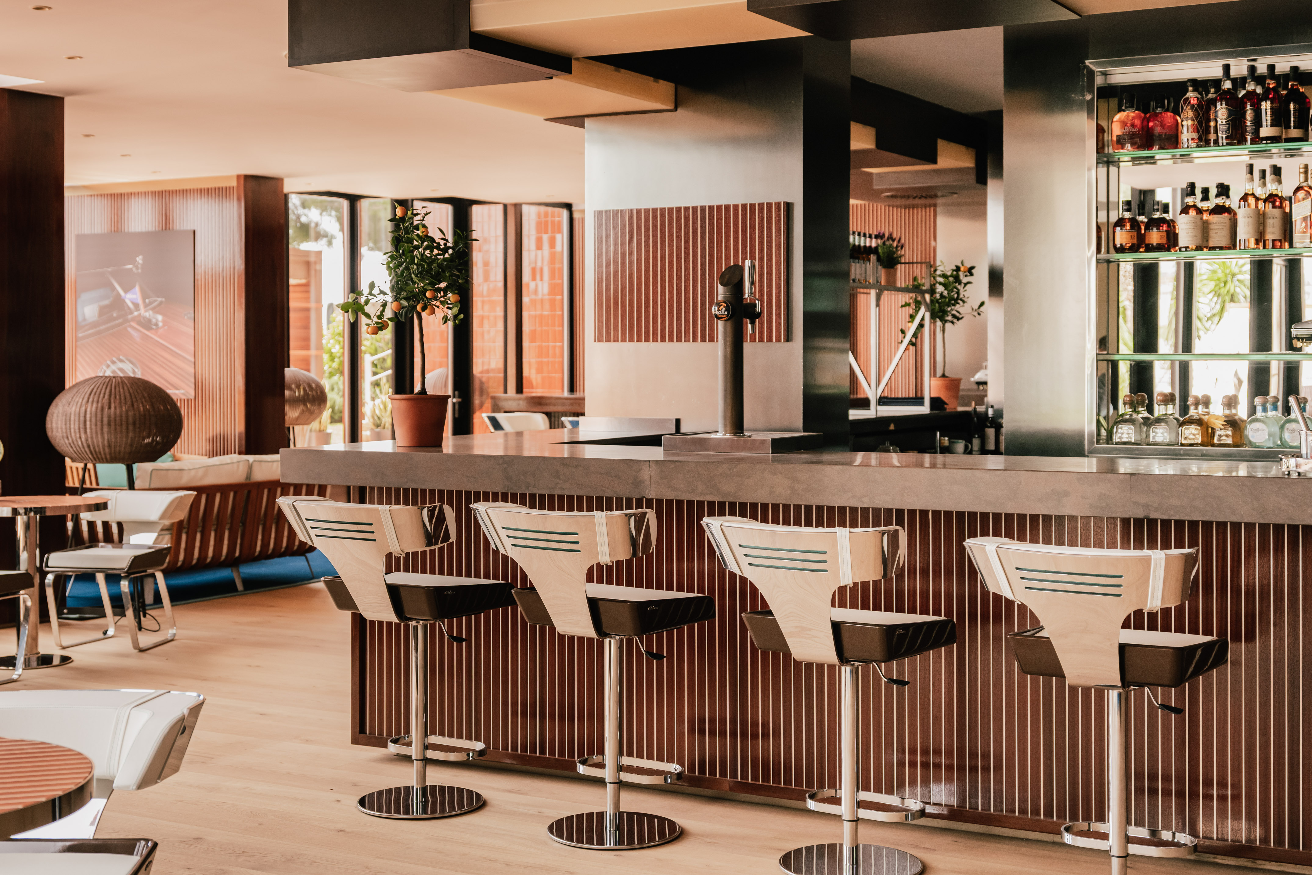 Modern bar interior with stylish stools, liquor display, and beer tap.