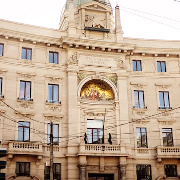 a building with a balcony and a statue on the side