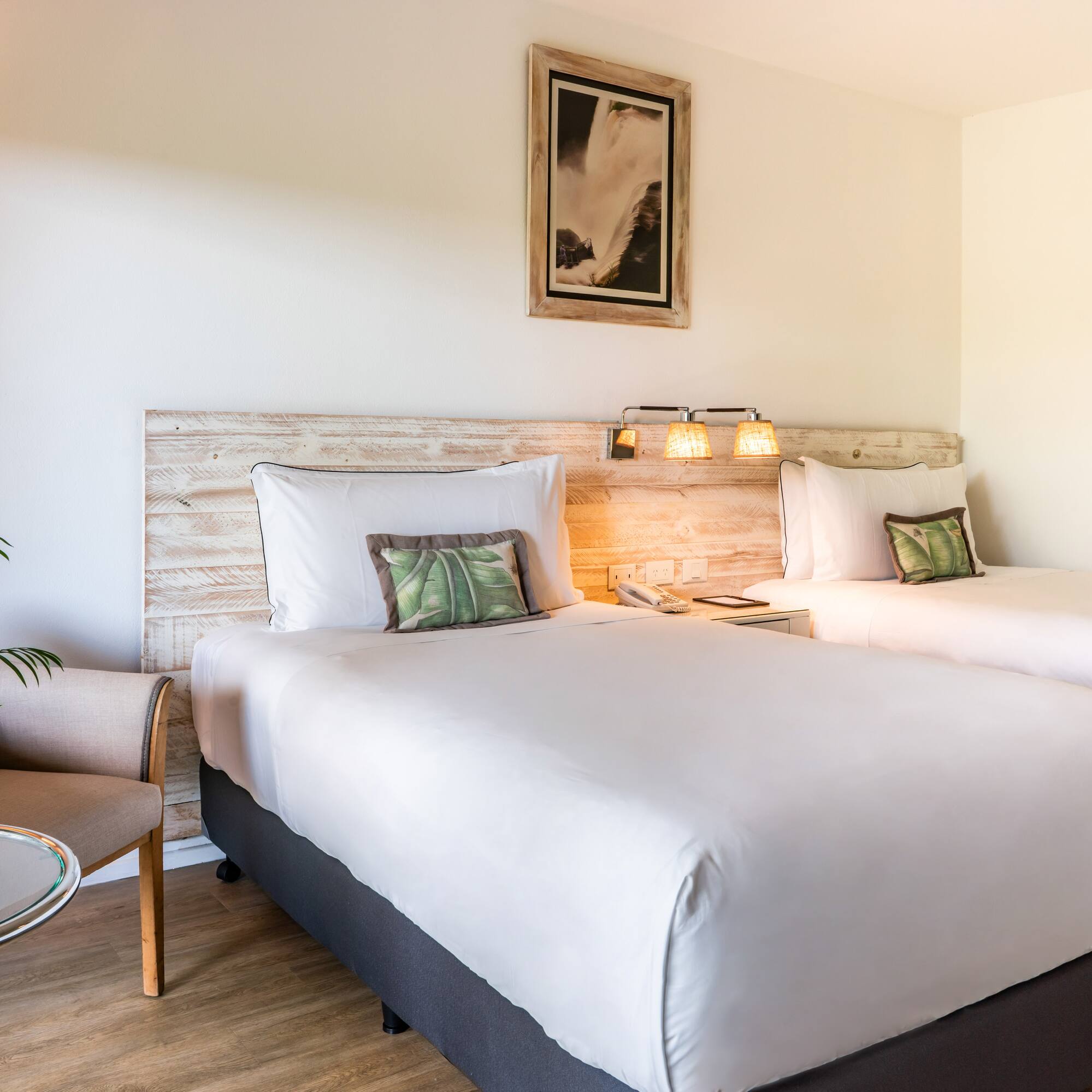 a room with two beds and a chair