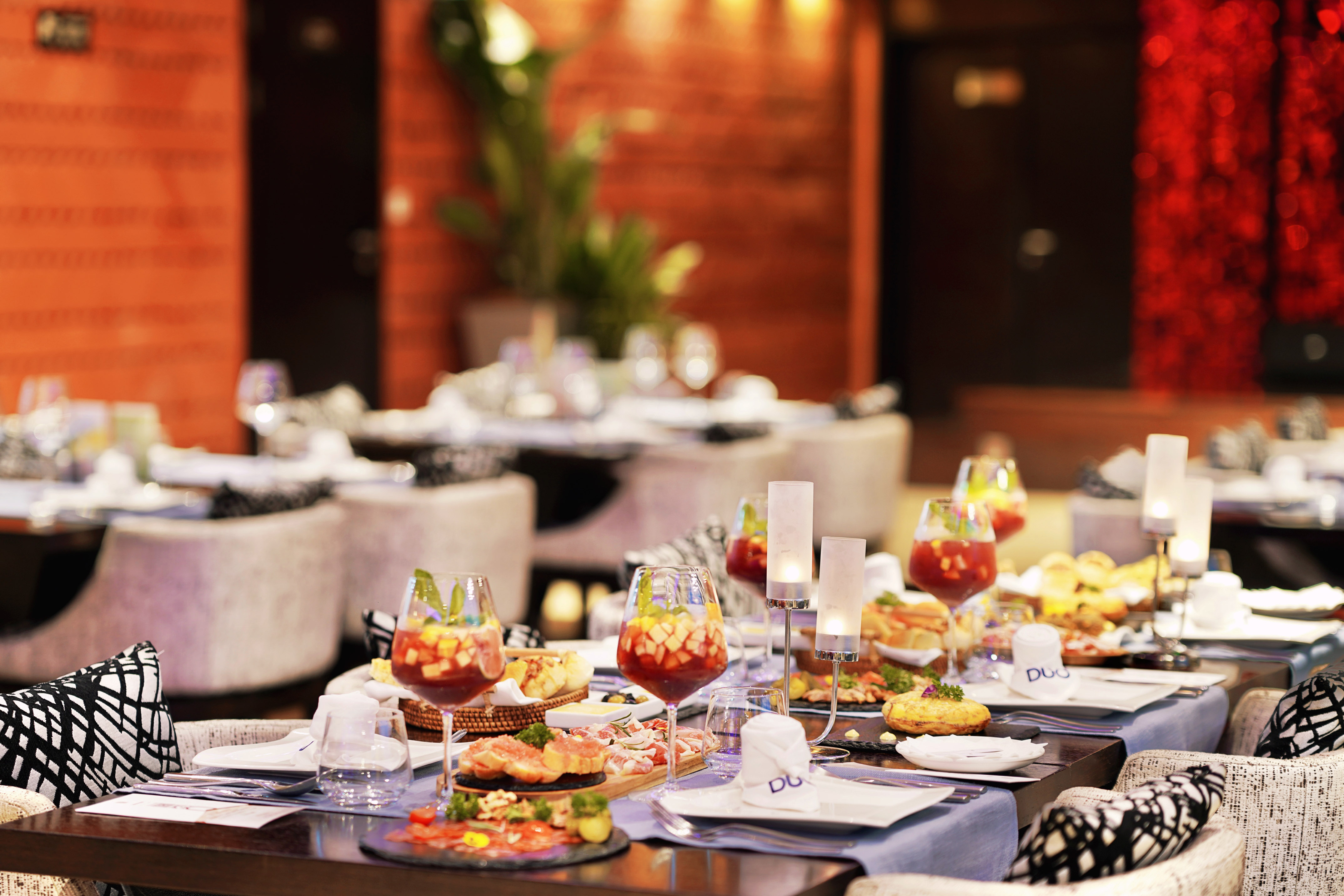 Elegant dining table with appetizers, fruit drinks, and candlelight.