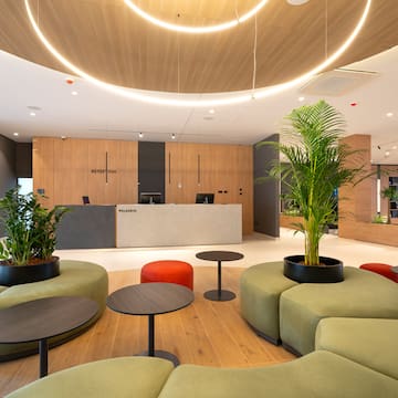 a lobby with a reception desk and a palm tree