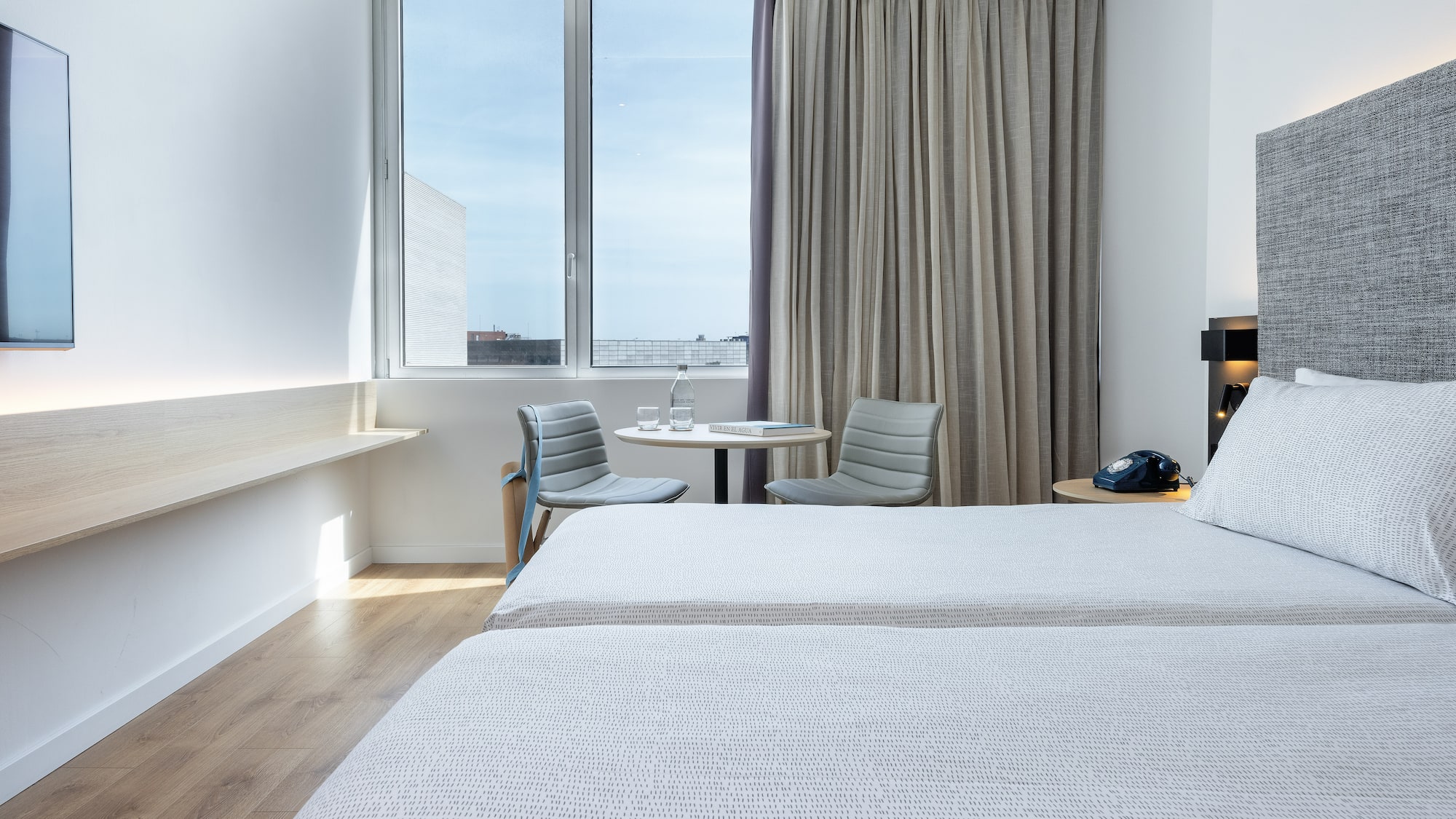 a room with two beds and a table and chairs