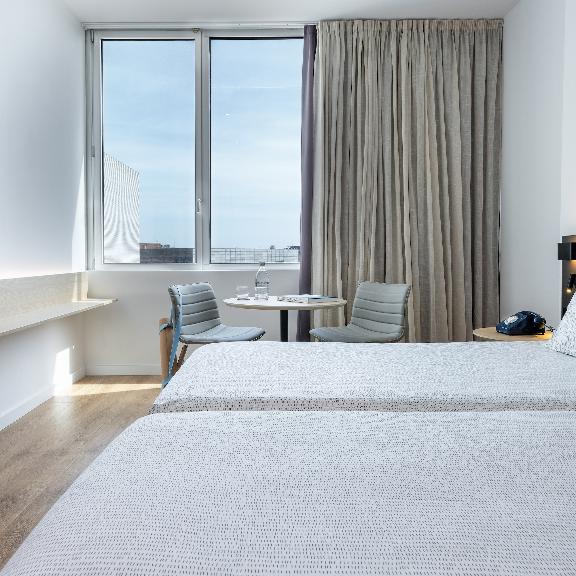 a room with two beds and a table and chairs