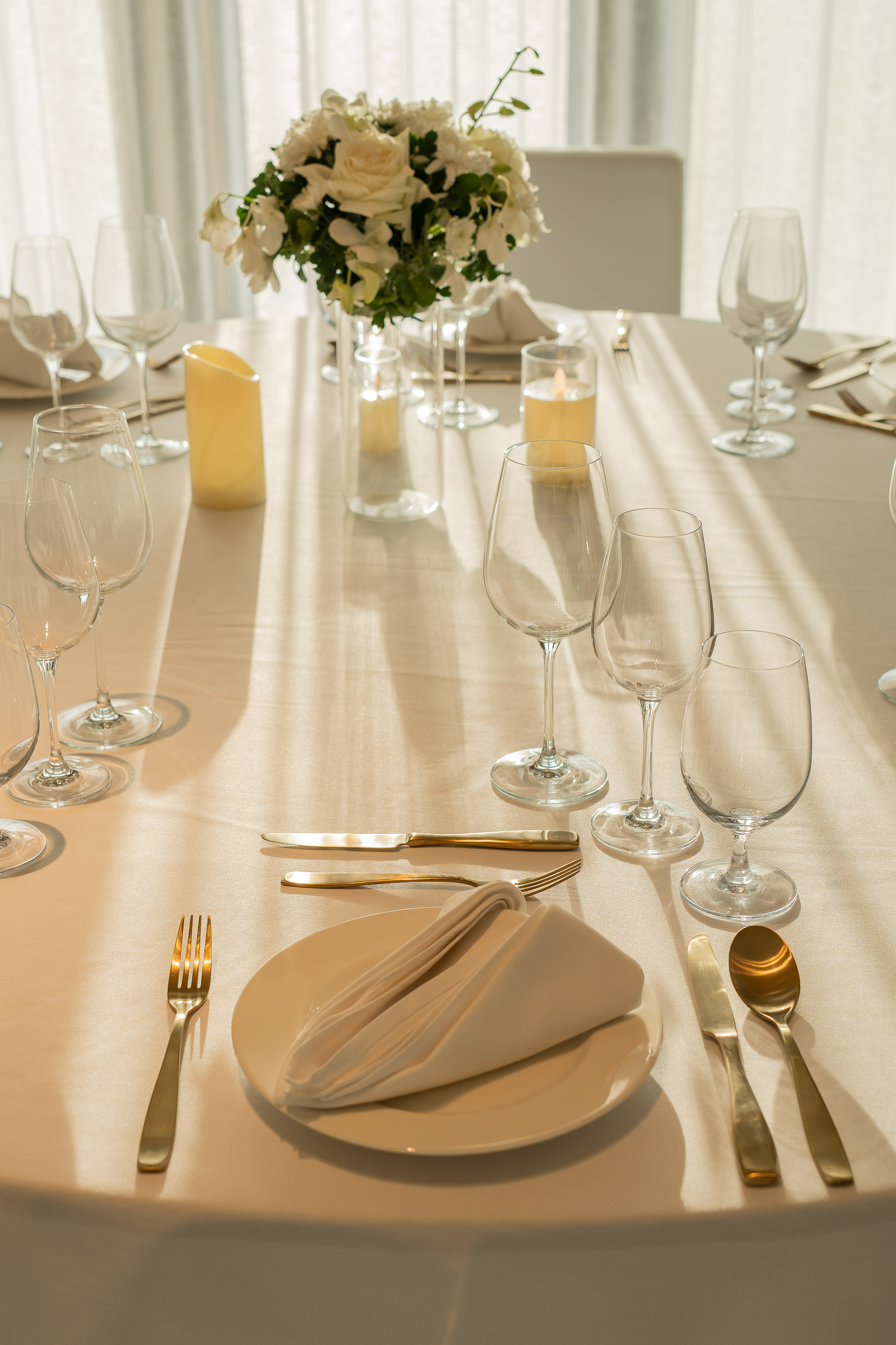 Elegant wedding table decor with white flowers, candles, and gold cutlery. - Nuaan - Meliá Pattaya Hotel, Pattaya