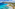 Turquoise Mediterranean coast, sandy beach, coastal village, and green mountains.