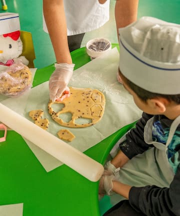 a person in a chef's hat making cookies