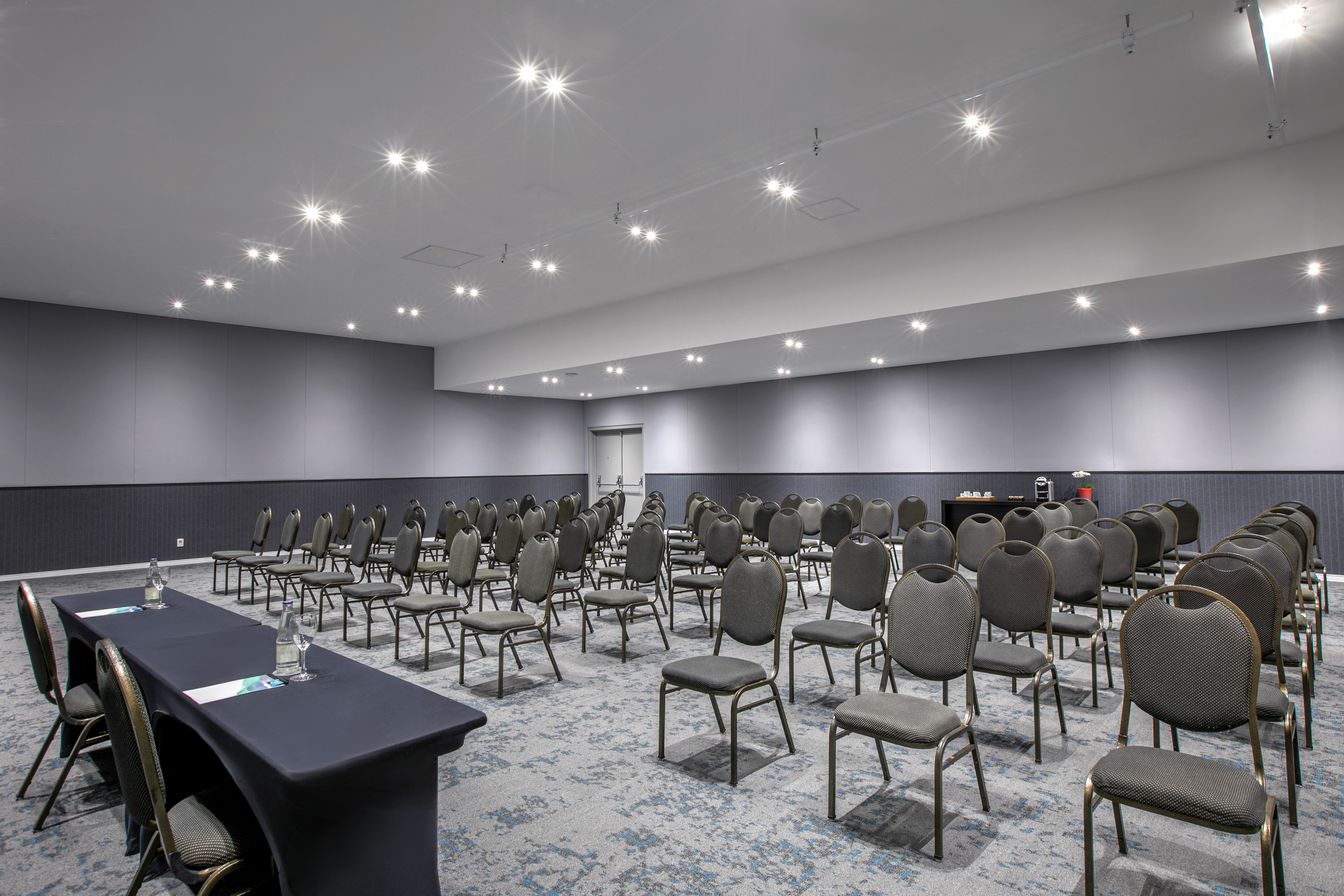 Empty modern conference room setup with chairs in rows and front table.