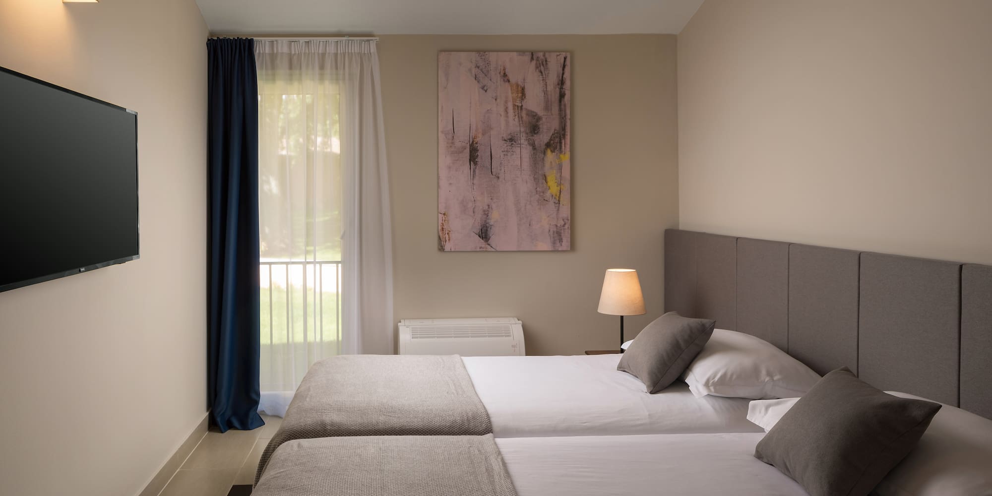 a room with two beds and a lamp