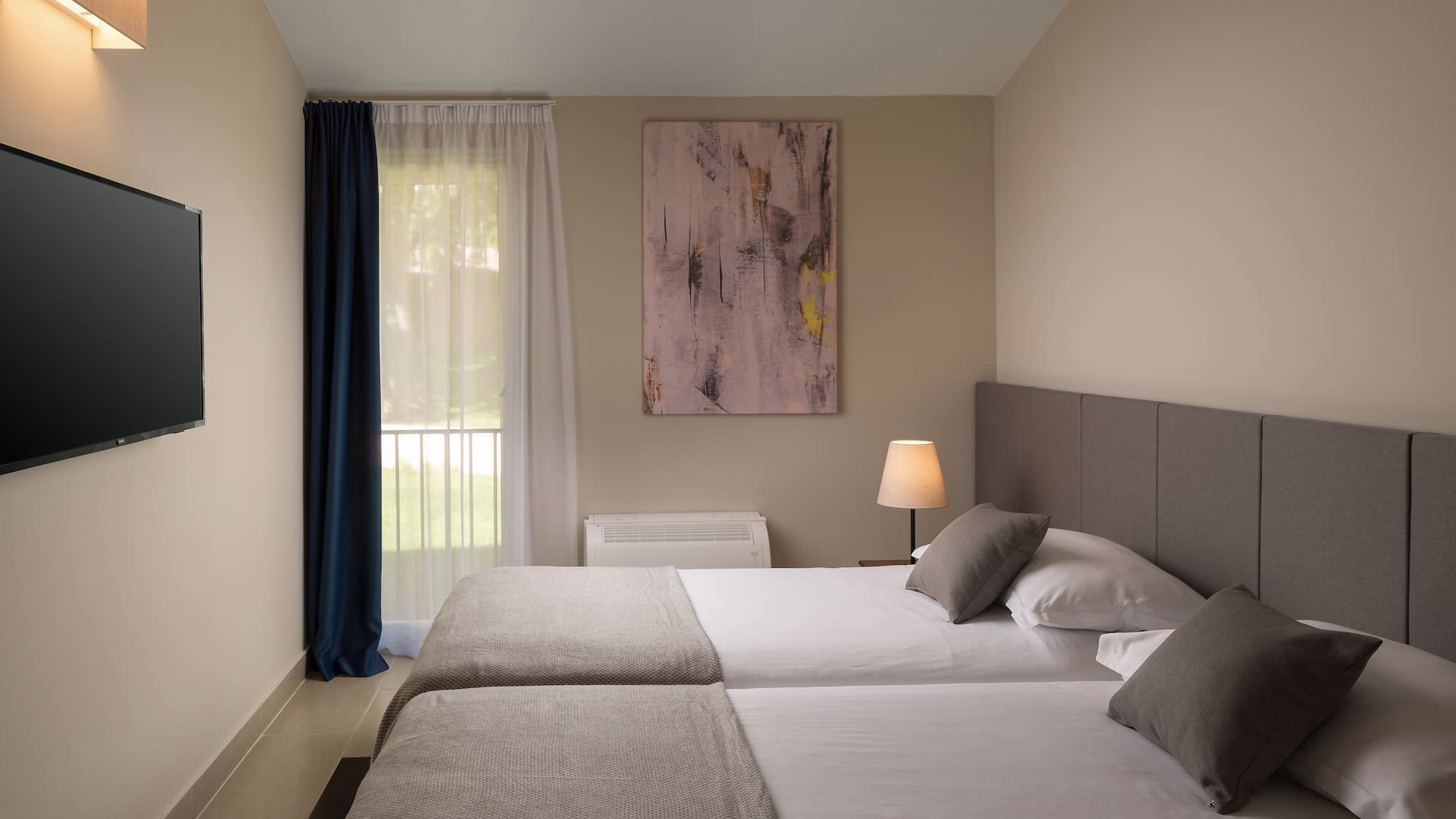 a room with two beds and a lamp