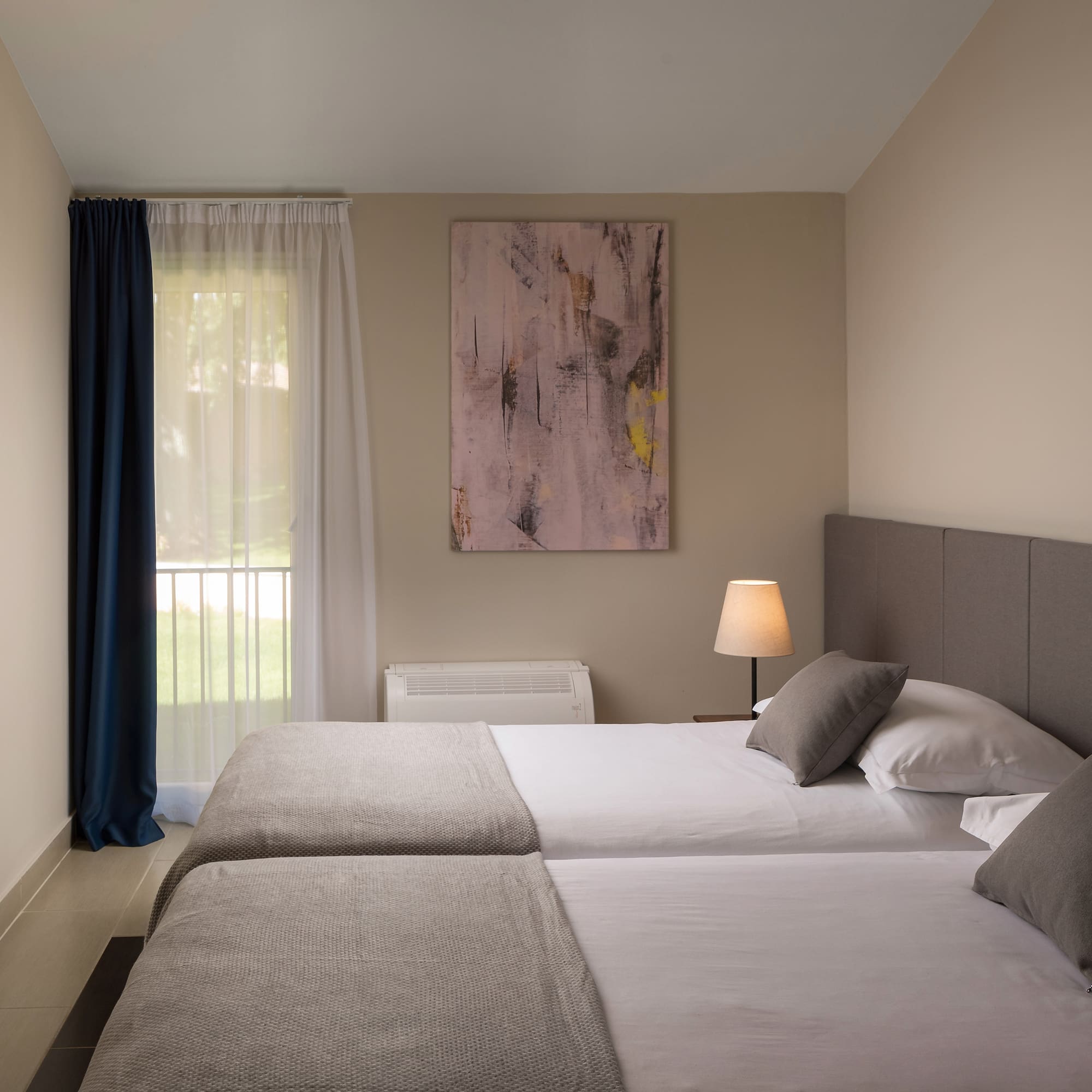 a room with two beds and a lamp