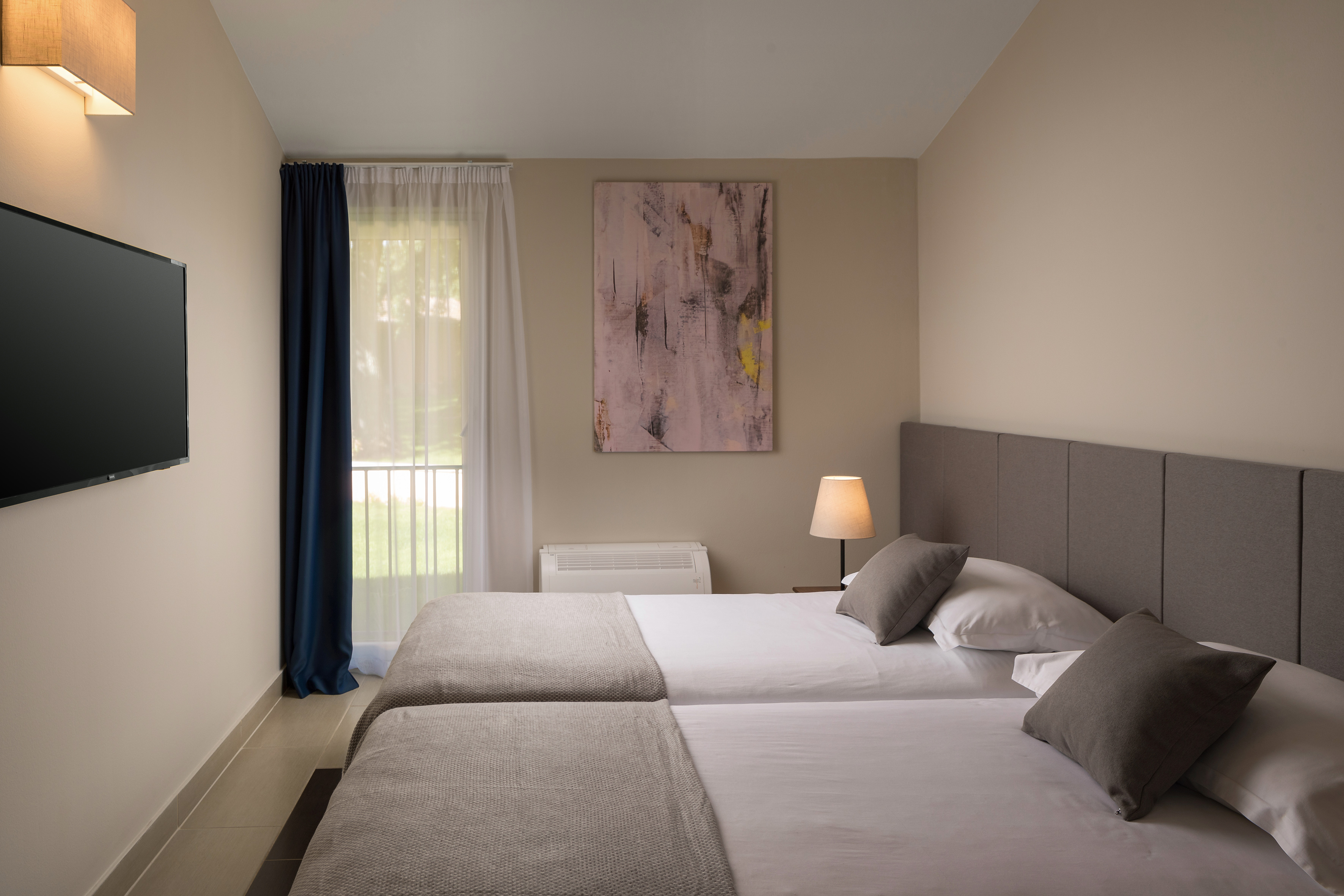 a room with two beds and a lamp