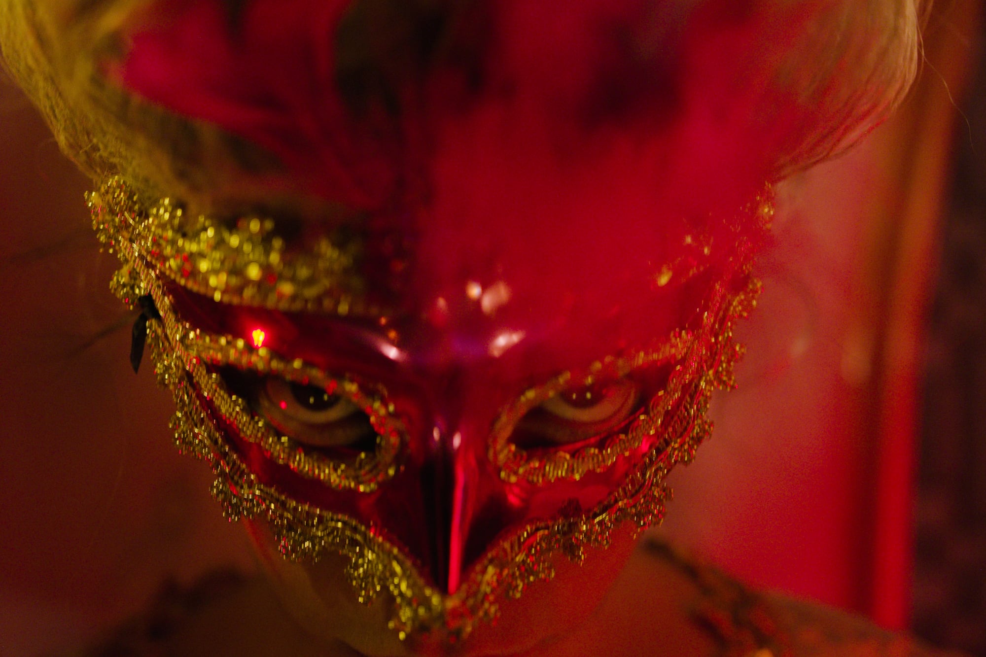 a person wearing a red and gold mask