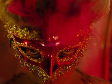 a person wearing a red and gold mask