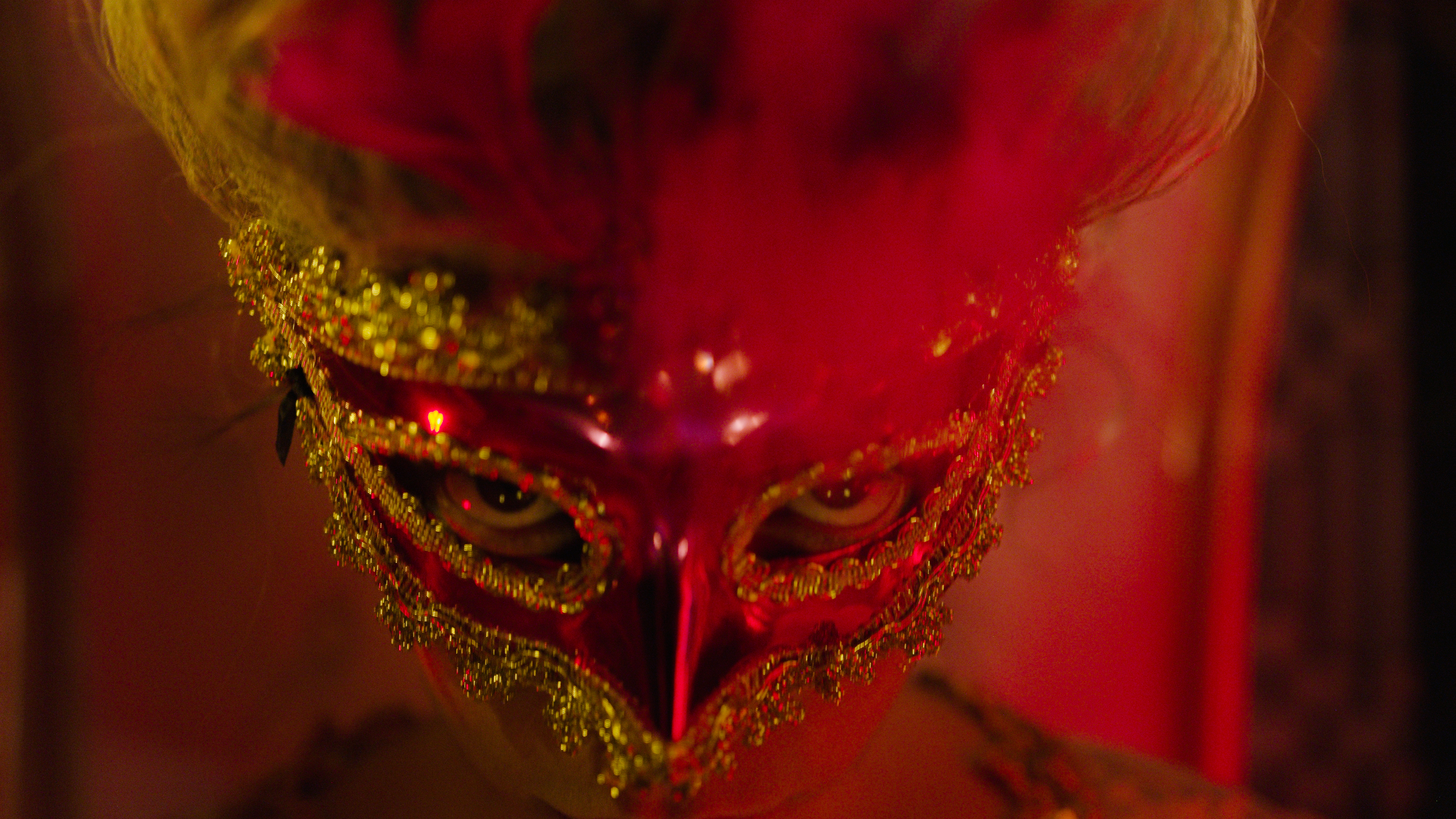 a person wearing a red and gold mask