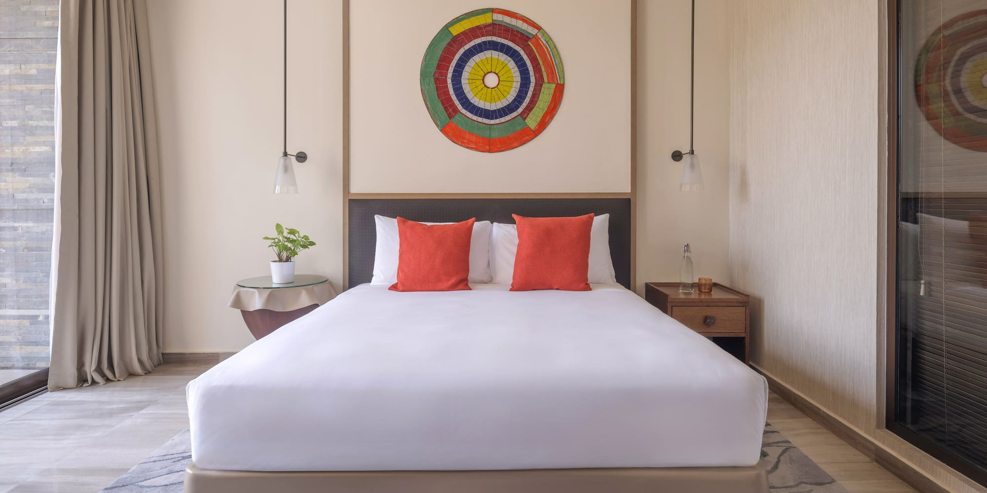 a bed with white sheets and red pillows