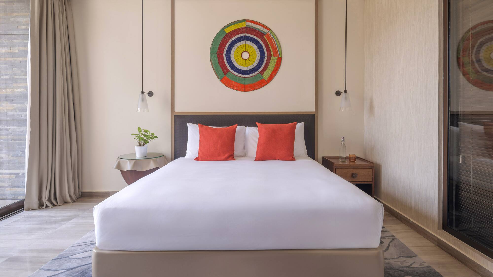 a bed with white sheets and red pillows