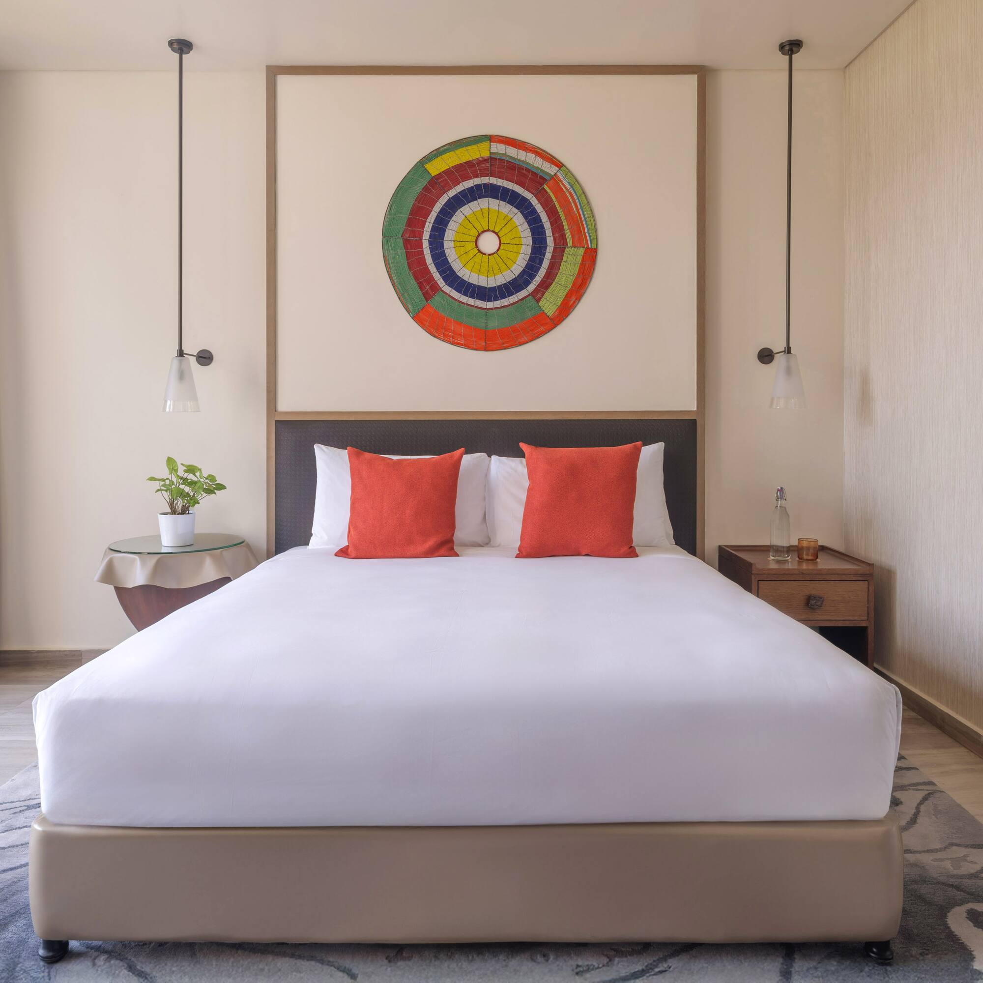 a bed with white sheets and red pillows