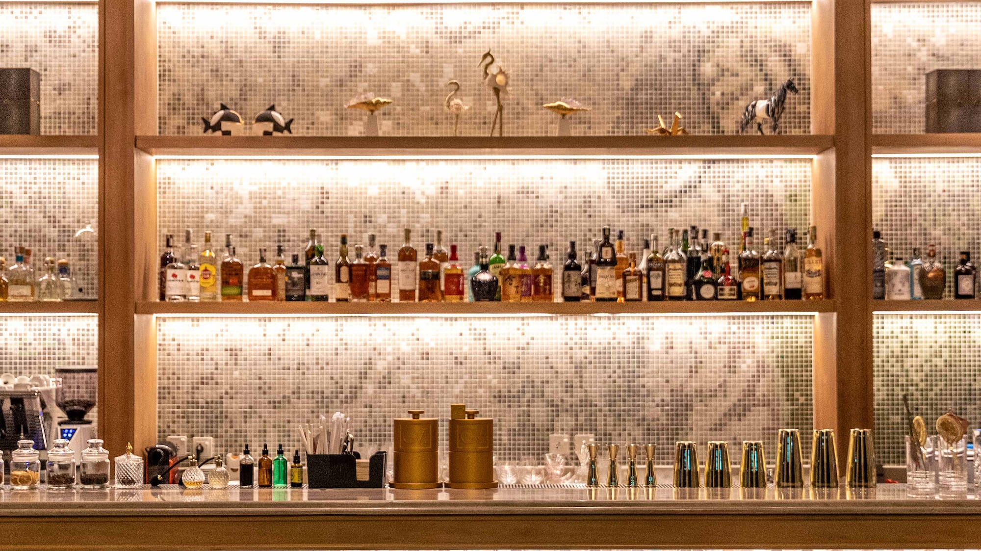 a bar with shelves of liquor and chairs