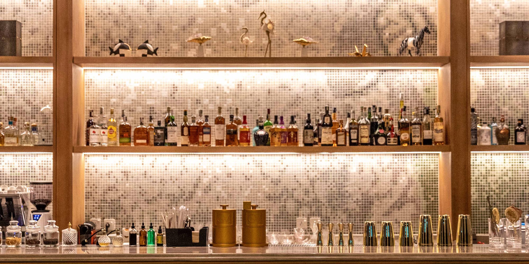 a bar with shelves of liquor and chairs
