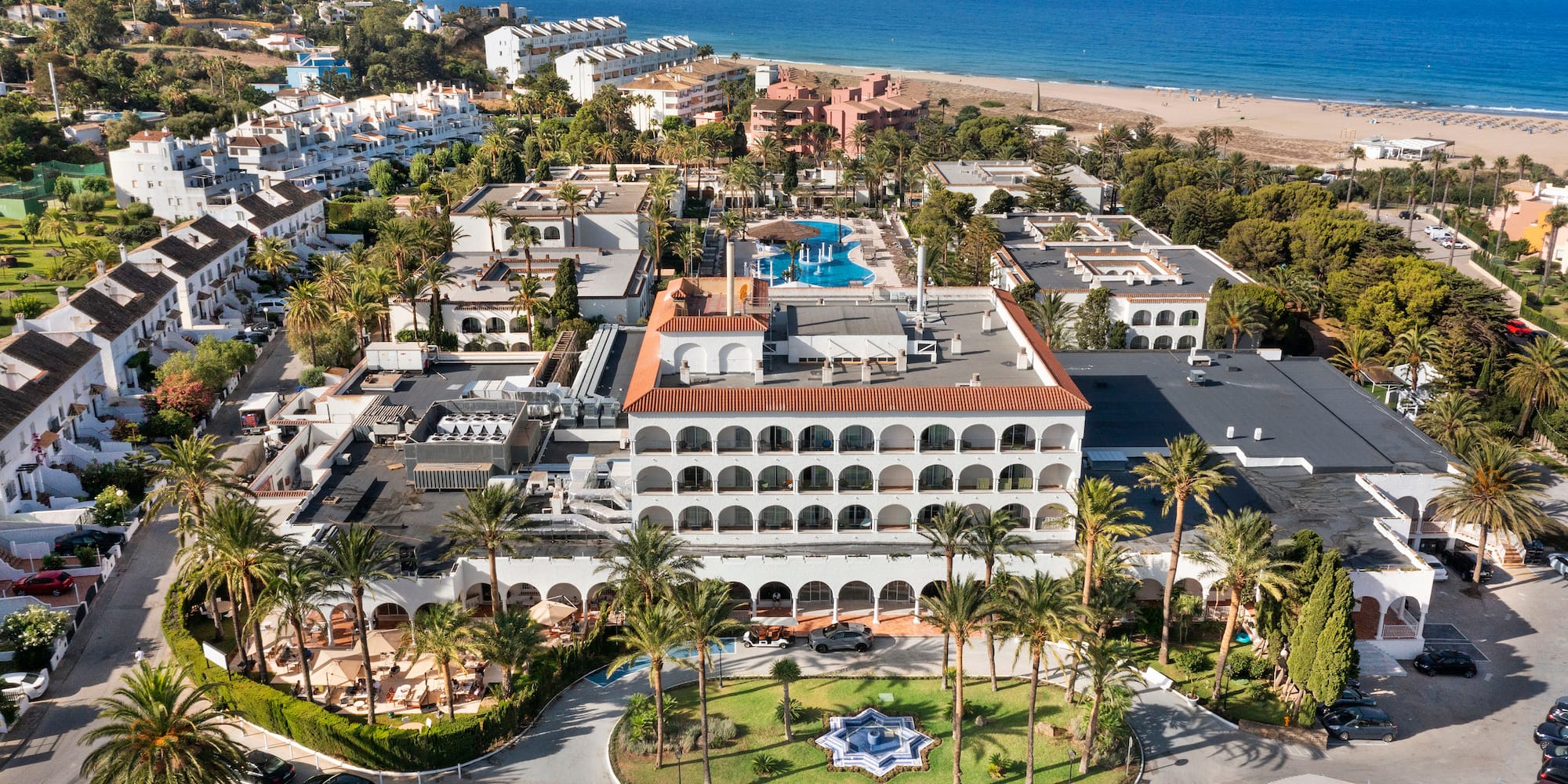 a aerial view of a resort with a pool and trees
