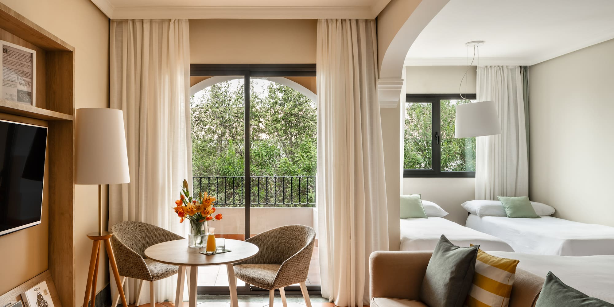 a room with a table and chairs and a bed and a balcony