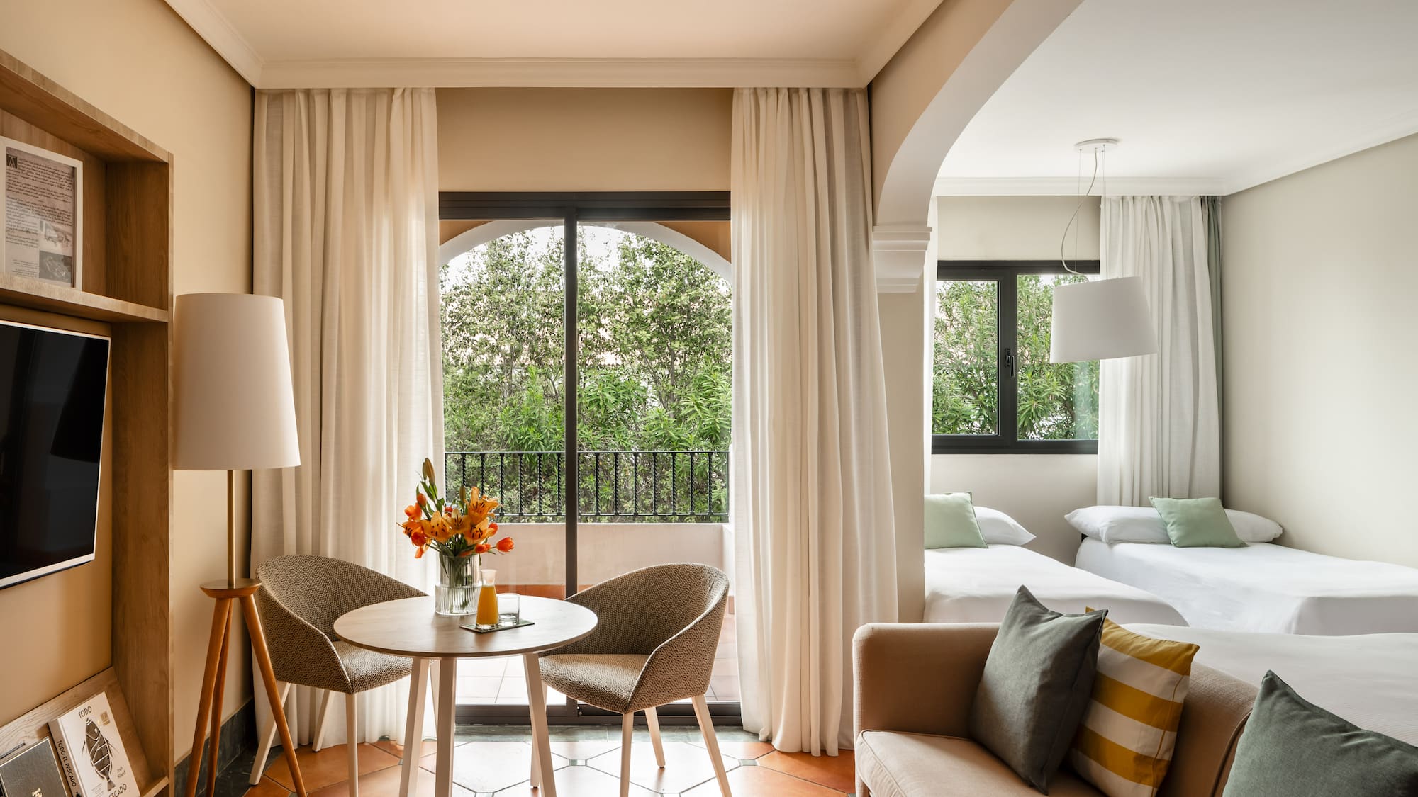 a room with a table and chairs and a bed and a balcony