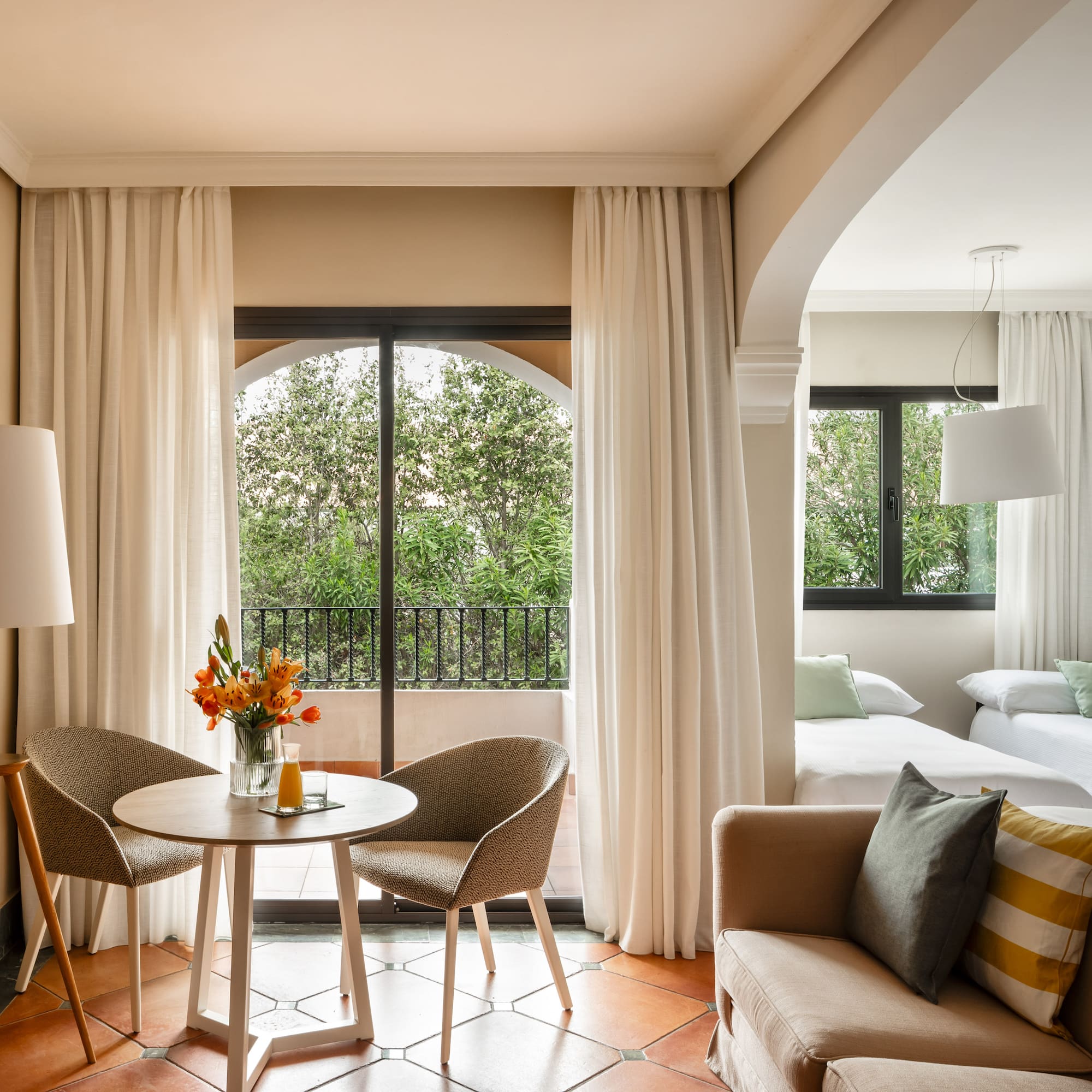 a room with a table and chairs and a bed and a balcony