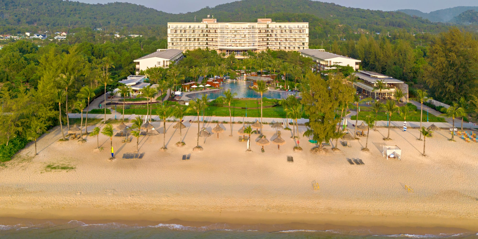 a beach with a hotel and a pool