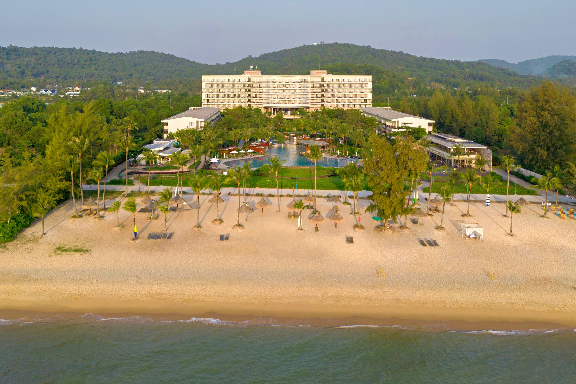 a beach with a hotel and a pool