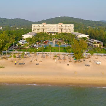 a beach with a hotel and a pool