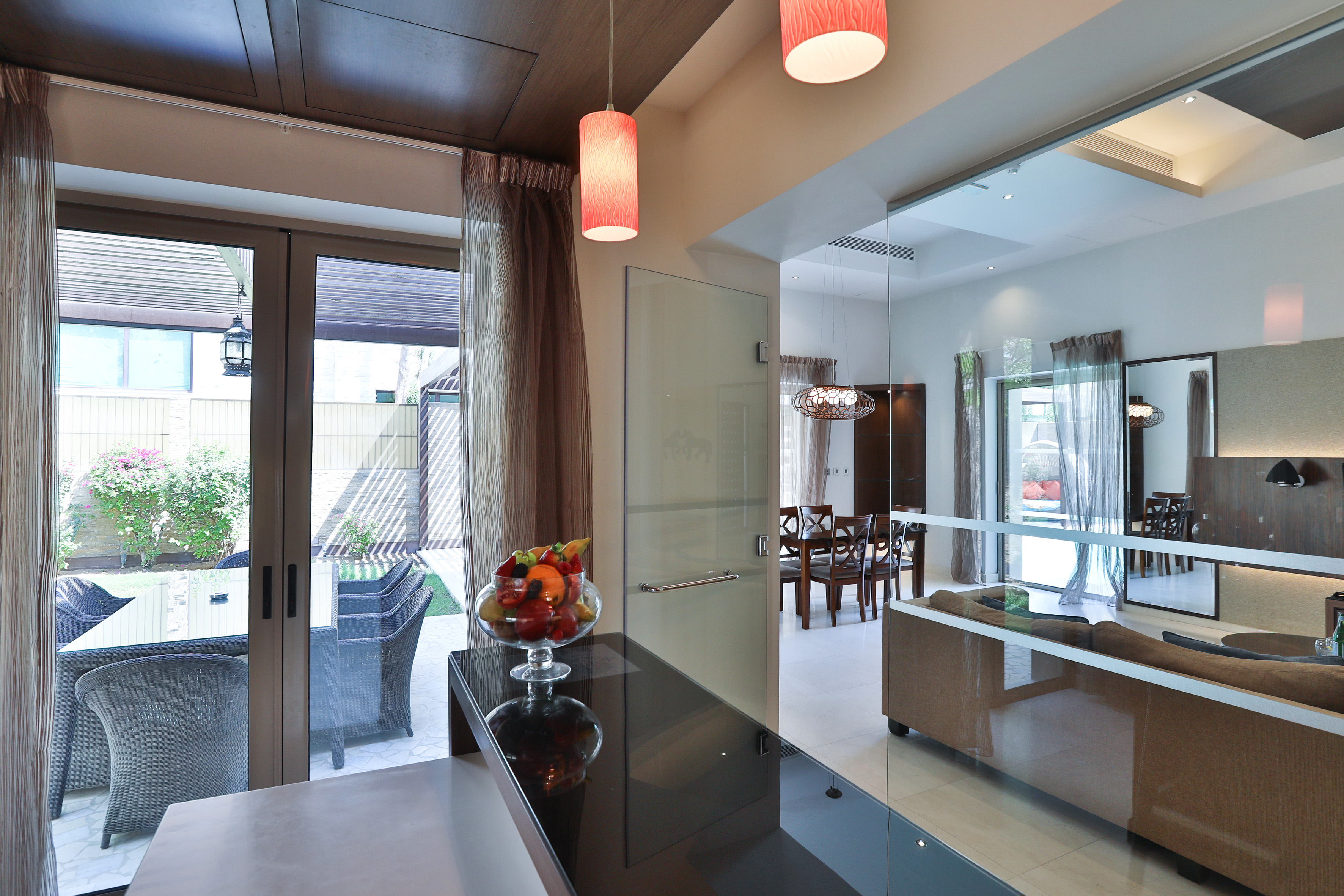 Modern open-plan interior with glass patio doors, dining space, and fruit display.