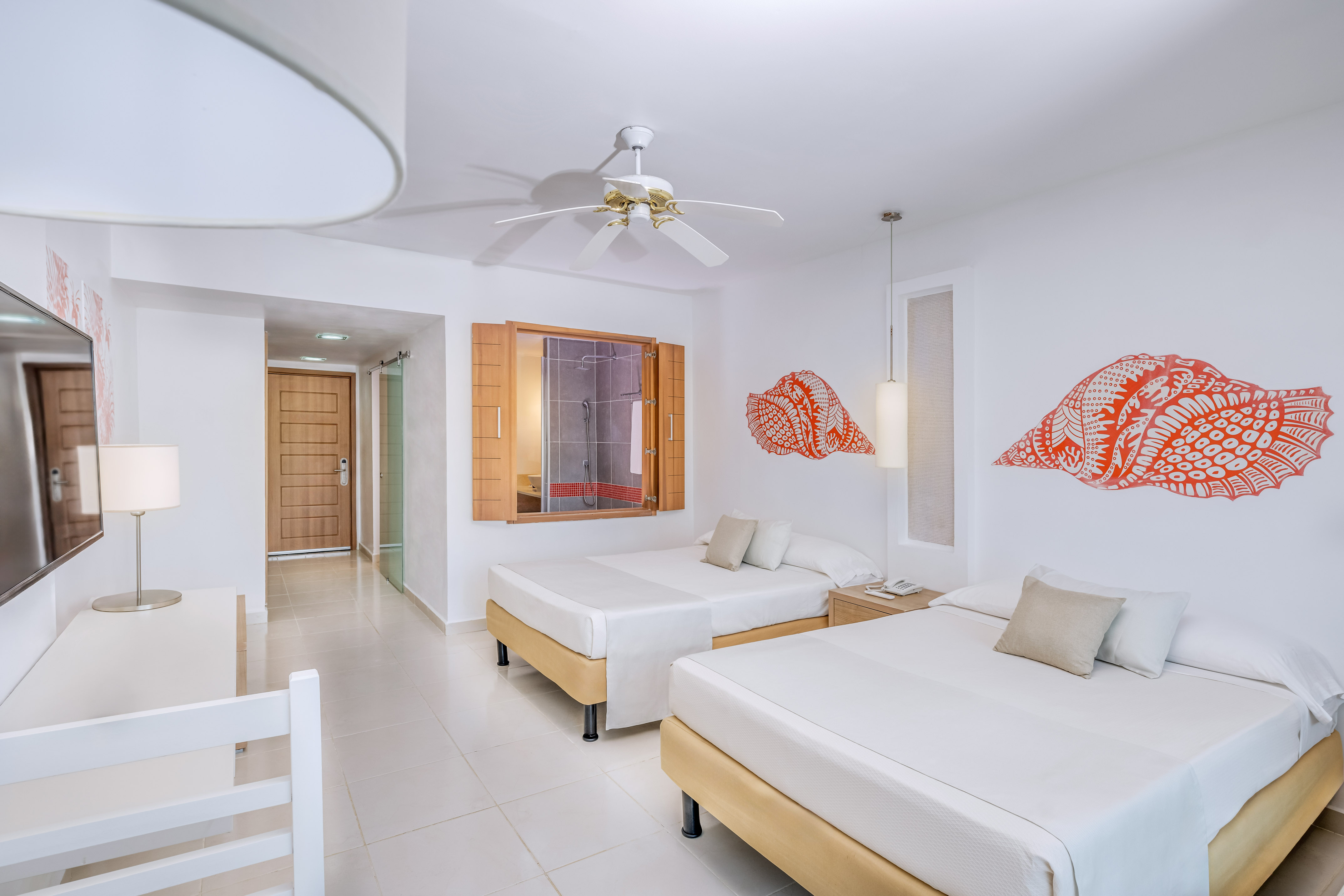 a room with two beds and a fan