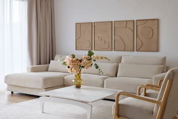 a living room with a couch and a vase of flowers