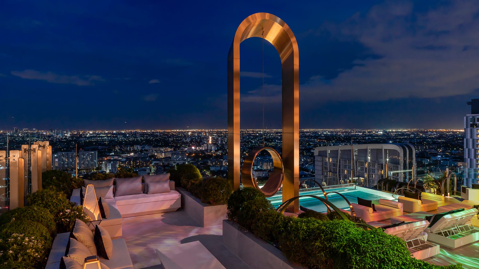 a rooftop with a pool and a large arch