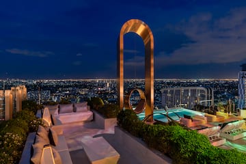 a rooftop with a pool and a large arch