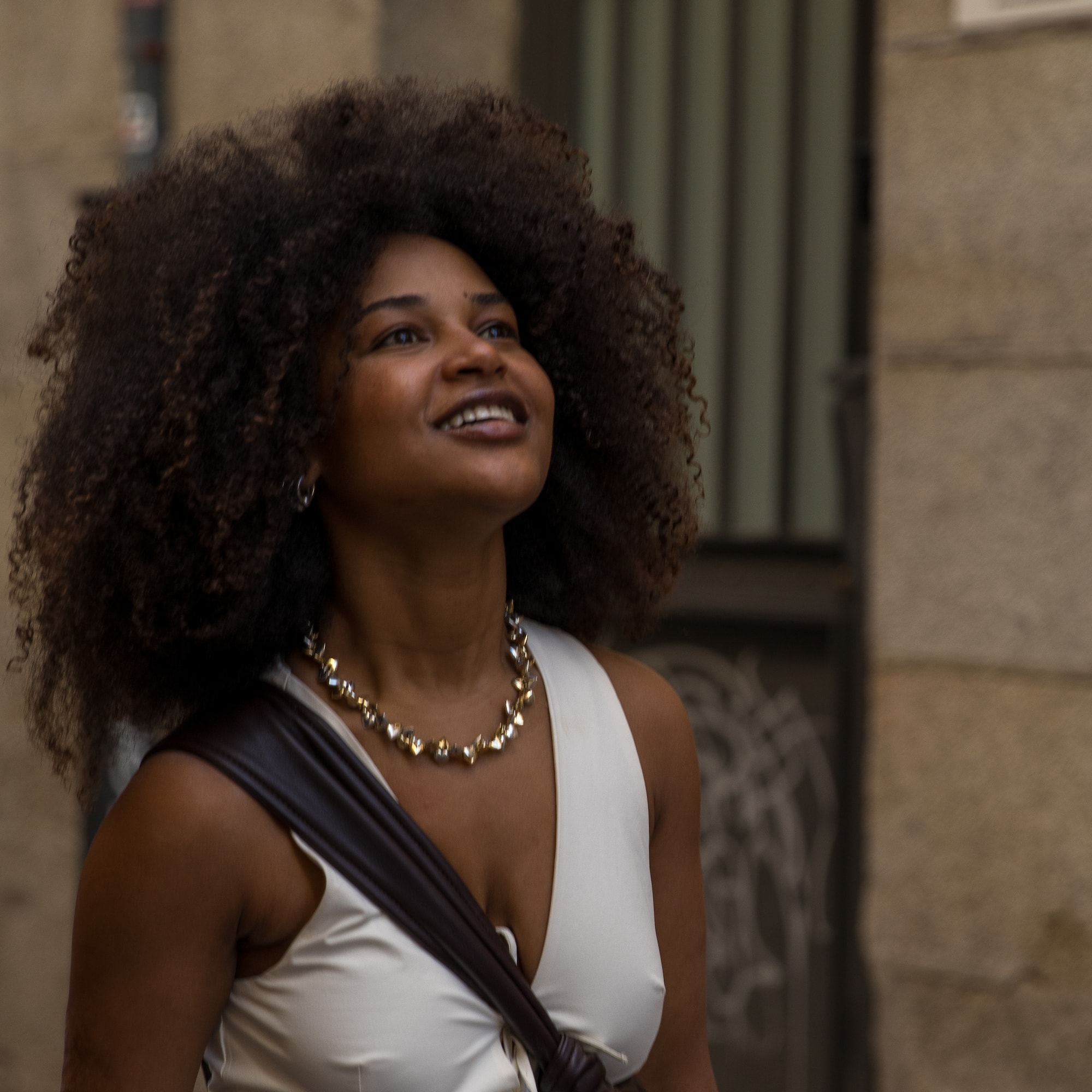 a woman with curly hair and a necklace