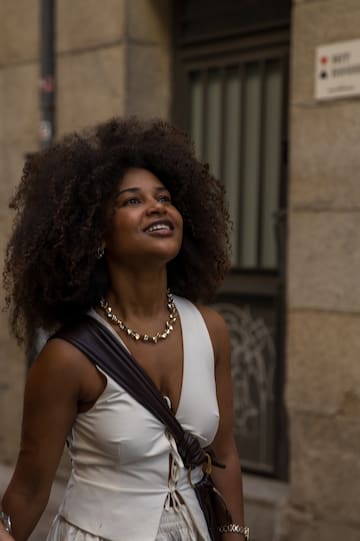 a woman with curly hair and a necklace