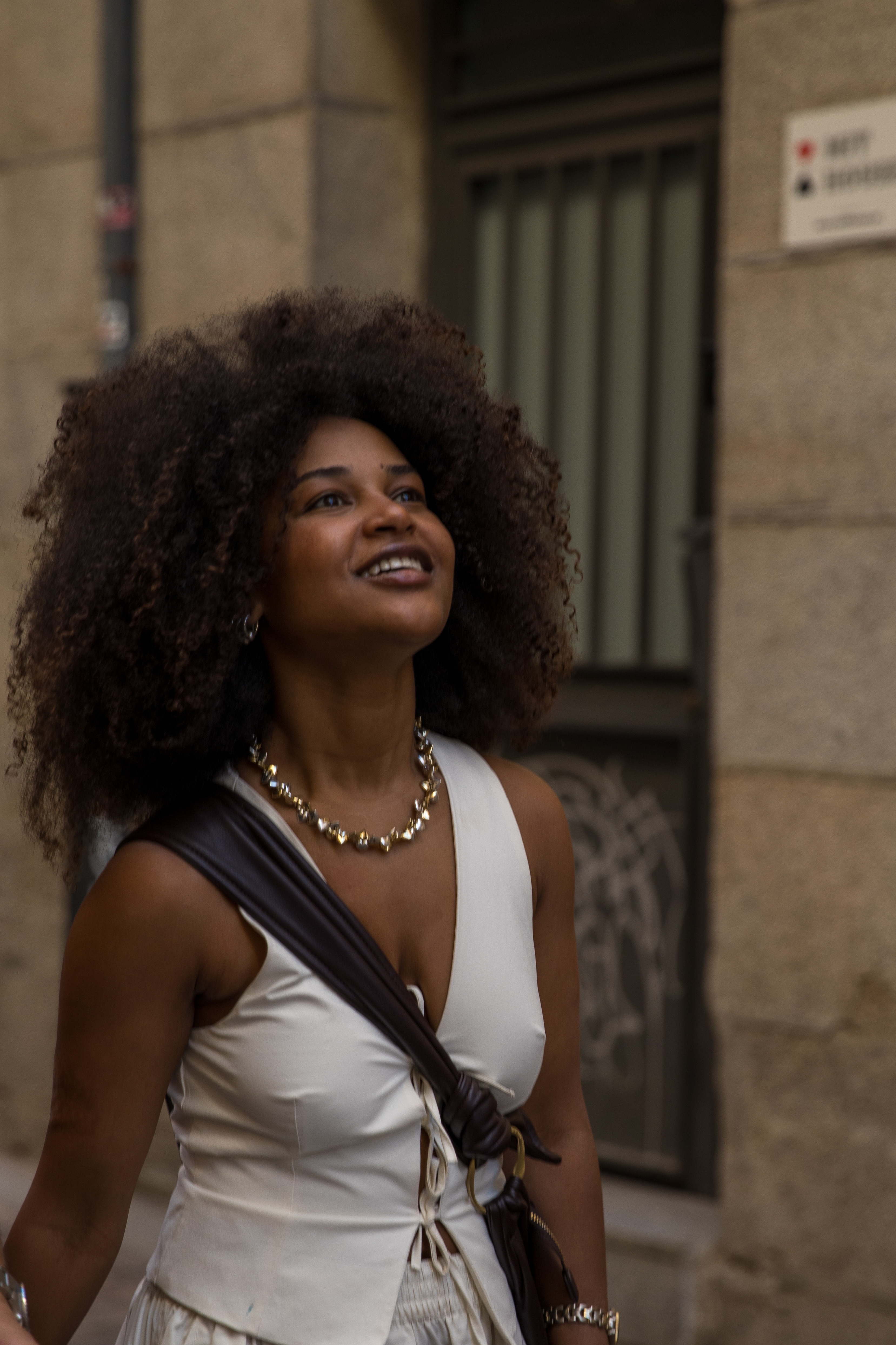 a woman with curly hair and a necklace