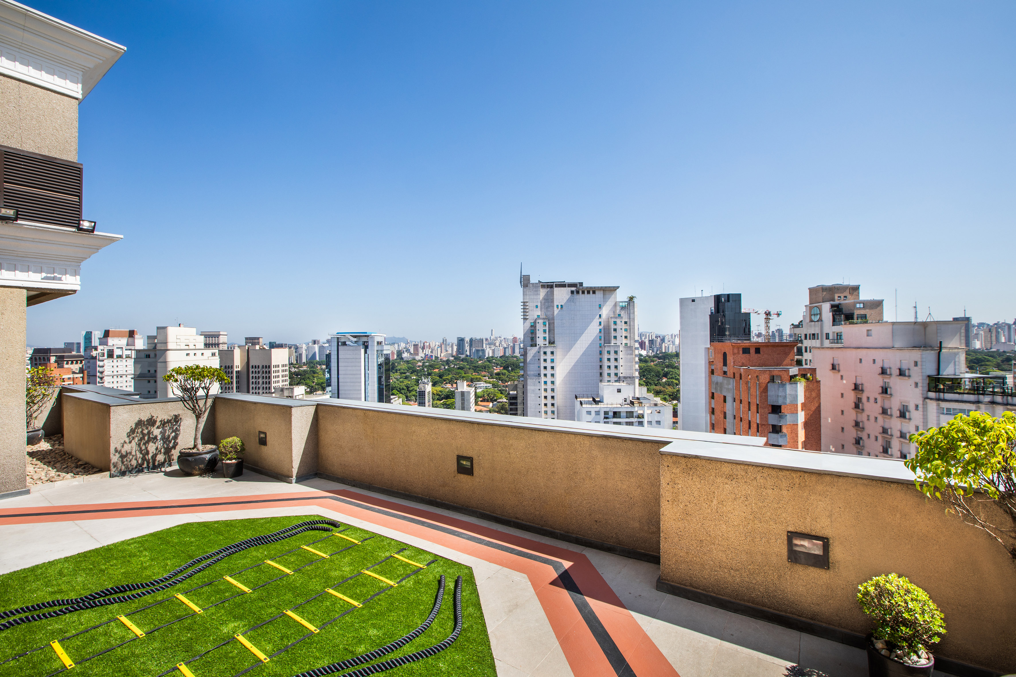 a rooftop with a green lawn and a city skyline
