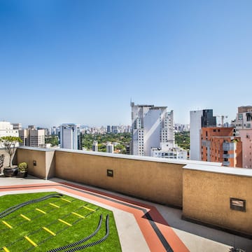 a rooftop with a green lawn and a city skyline