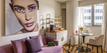 a living room with a couch and a poster on the wall